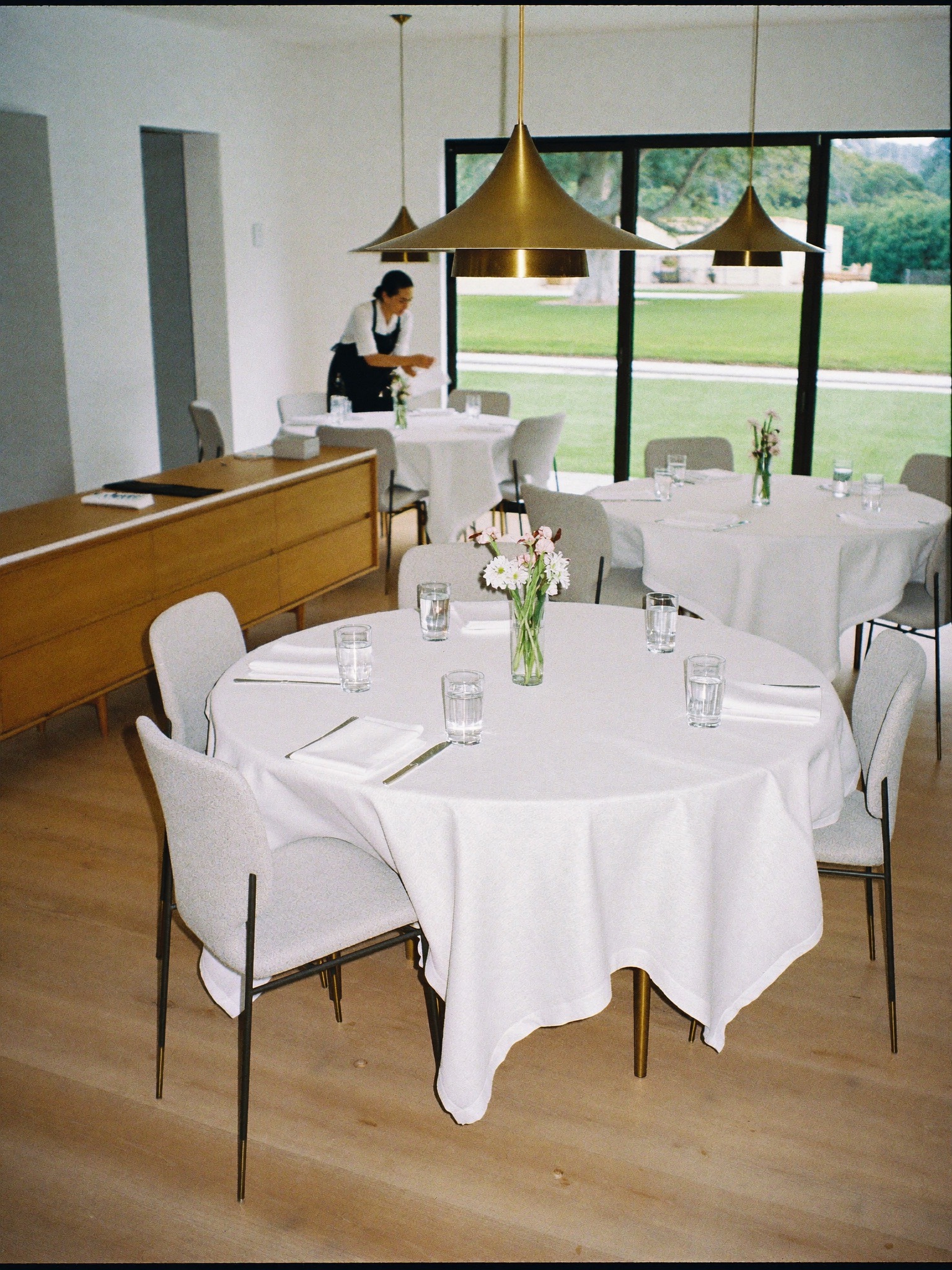 Staff member setting tables in an assisted living dining room