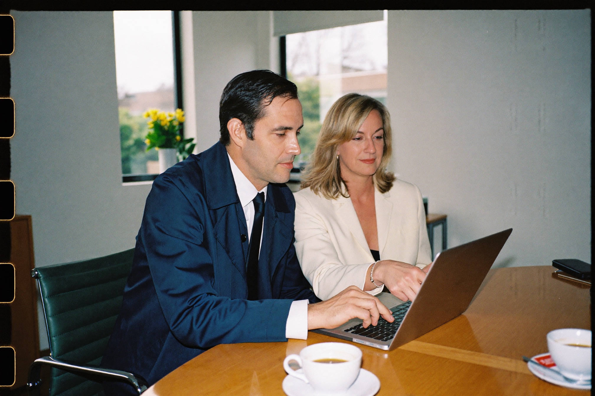 Two facility owners reviewing a report at a laptop