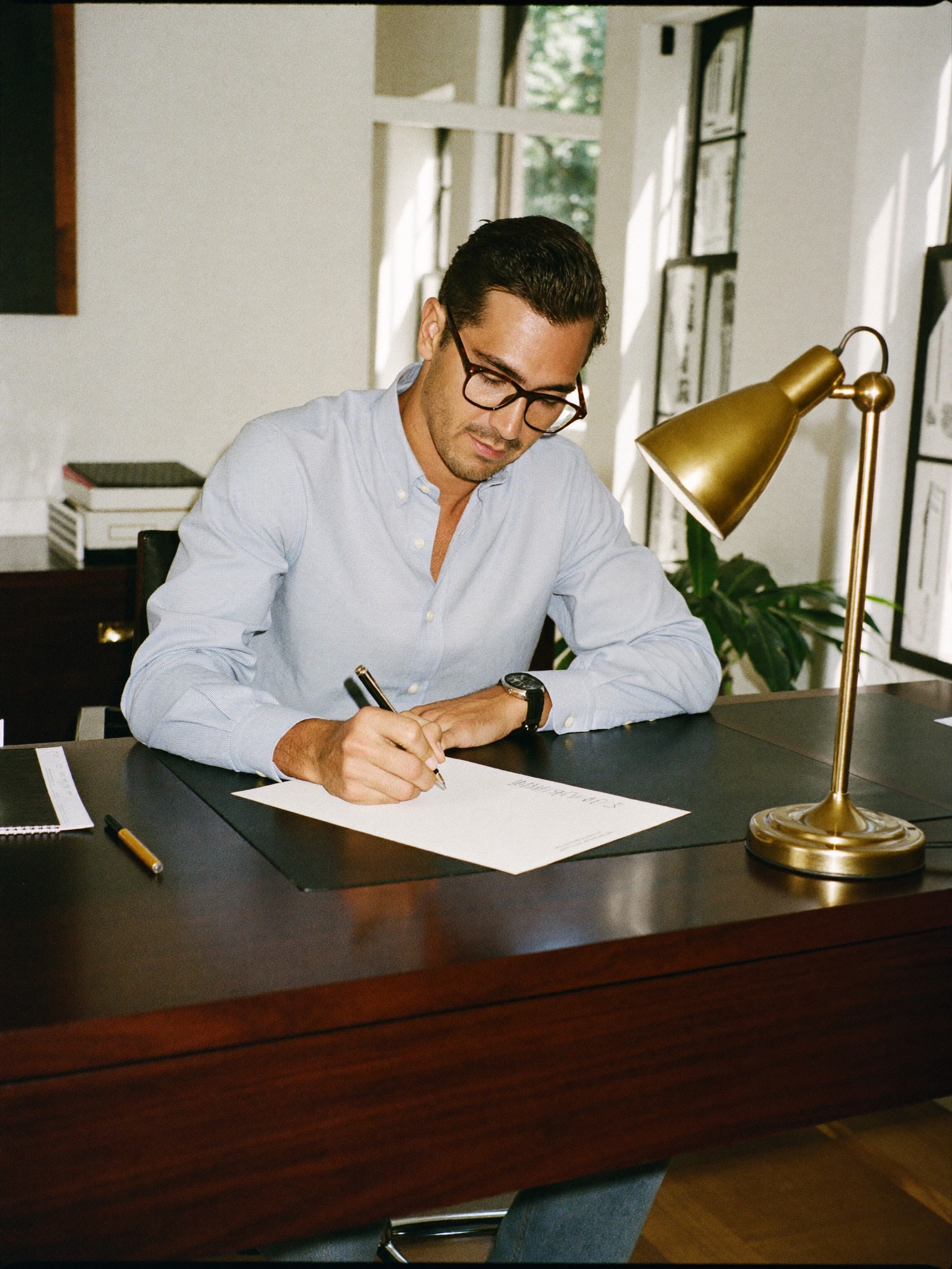 Billing specialist writing a note at his desk