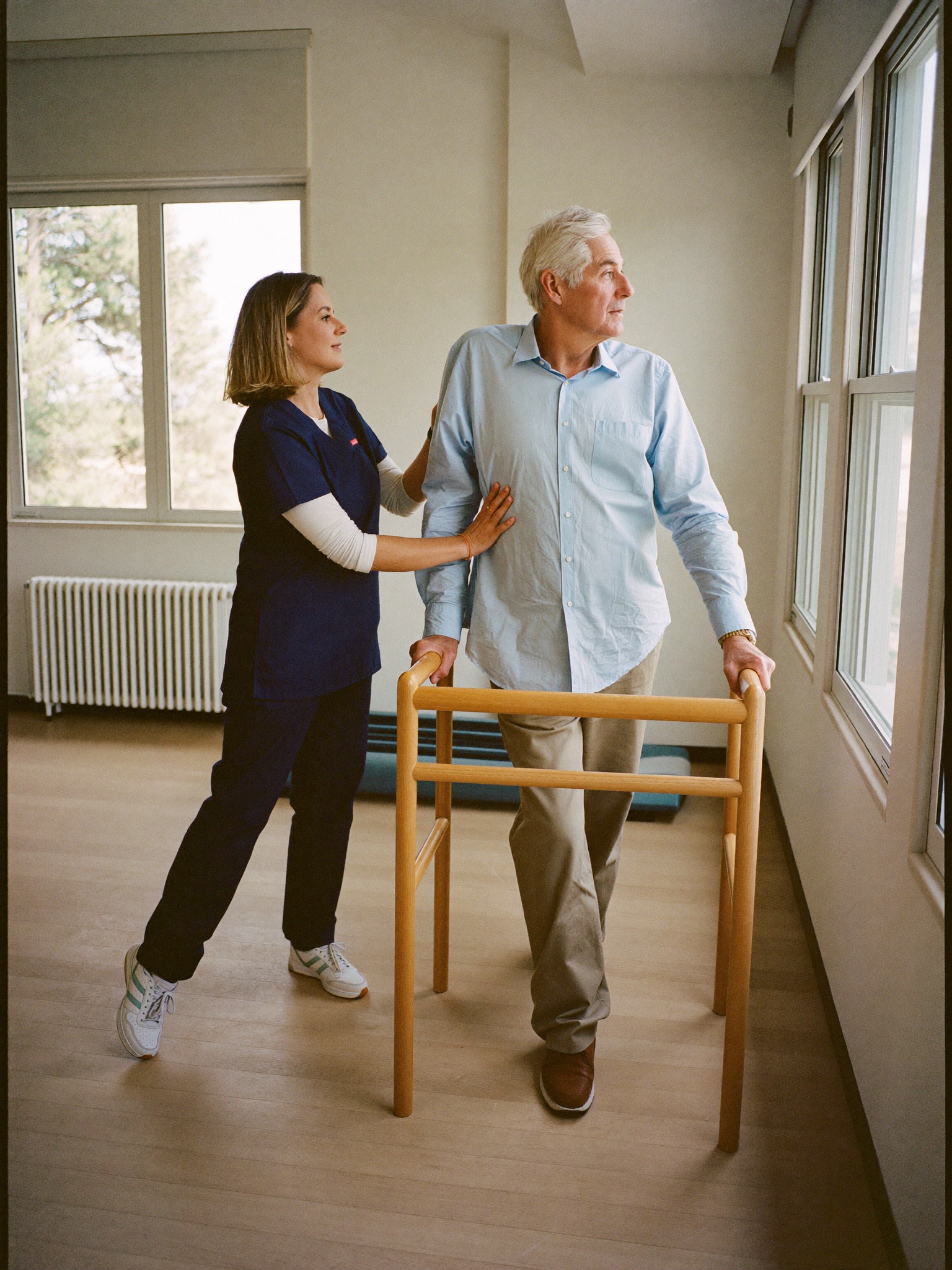 Therapist helping a resident with a resistance band in a rehab room